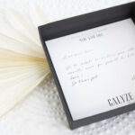 message personnalisé dans un étui noir avec une fleur séchée