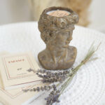 Bougie blanche dans un pot en forme de visage