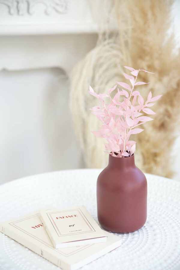 pot de couleur bordeaux avec des fleurs séchées roses claires à l'intérieur