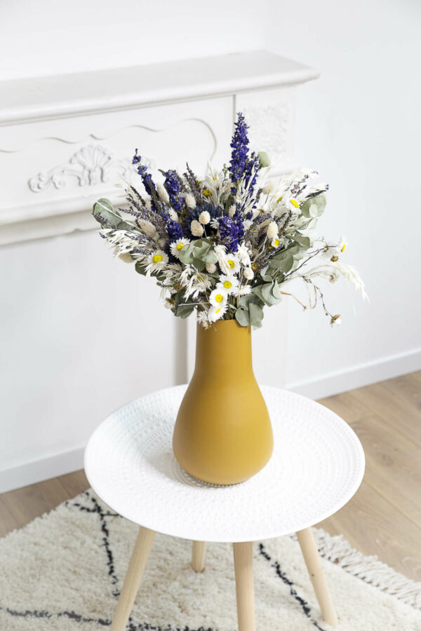 Bouquet de fleurs séchées dans un vase moutarde