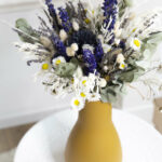 Bouquet de fleurs séchées dans un vase moutarde